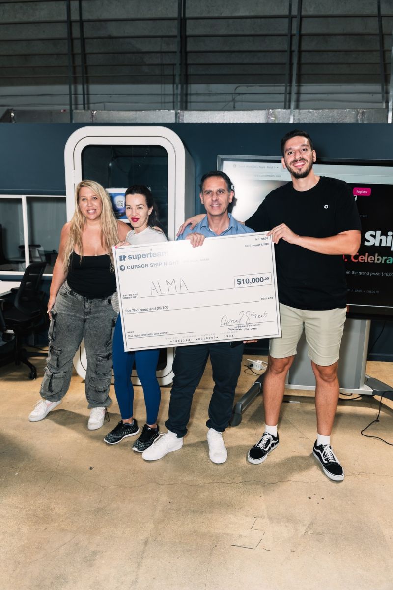 Four members of Team ALMA holding an oversized Superteam USA Cursor Ship Night check for $10,000 made out to ALMA